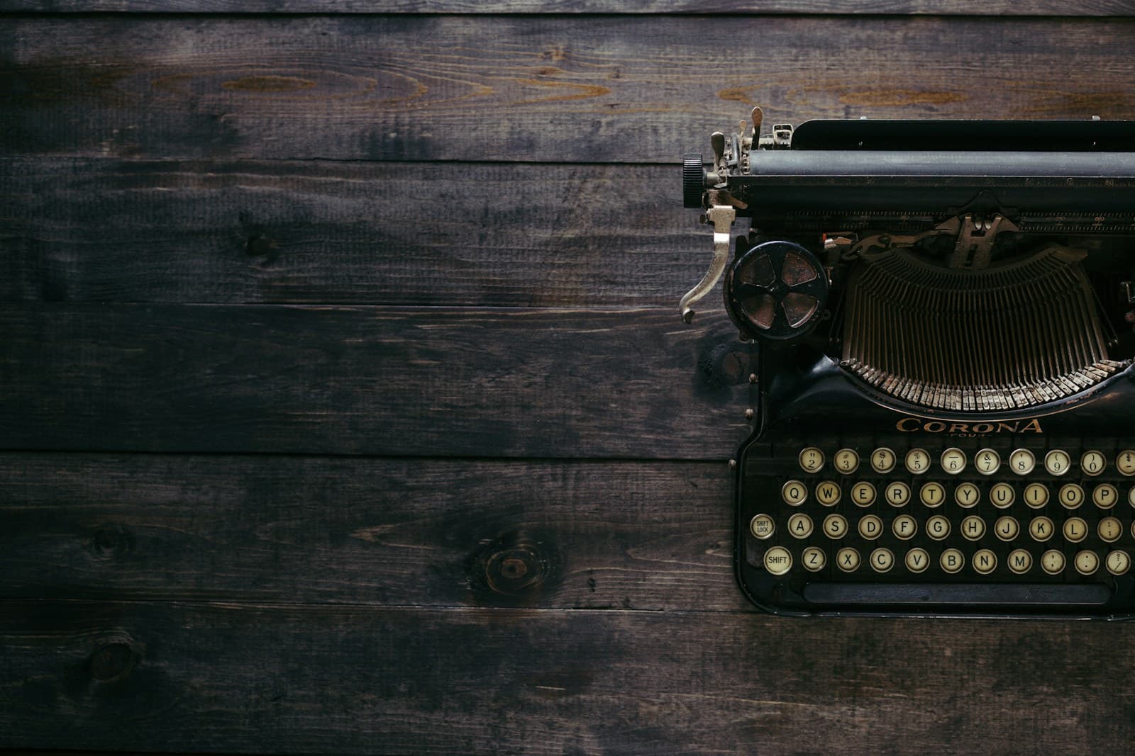A vintage typewriter sitting on rough-sawn wood planks