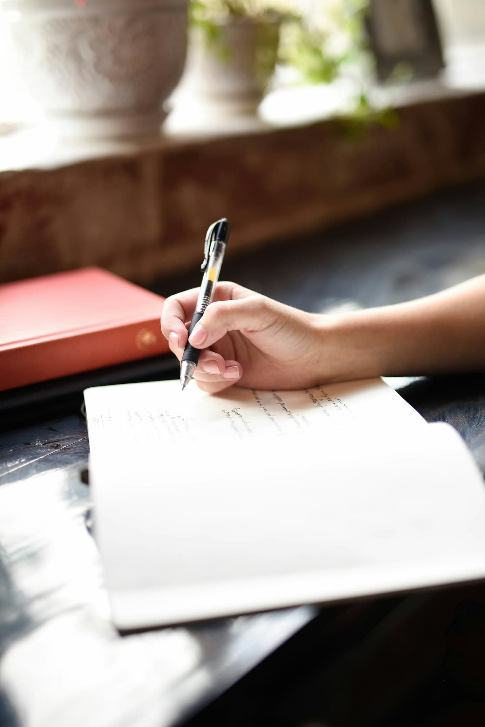 A journal and coffee mug on a wooden surface in morning light